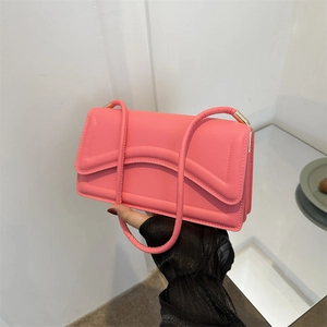 Pink minimalist underarm bag with wavy quilted stitching and gold hardware details