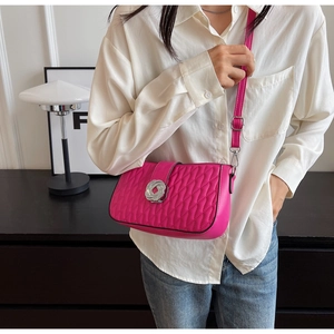 Close-up of hot pink quilted crossbody bag featuring a decorative silver woven knot buckle