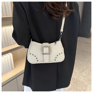 Detail of off-white canvas shoulder bag with metallic rivets and large square buckle
