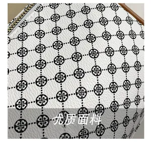 Detail of lychee pattern white leather bag with black geometric heart print and gold zipper