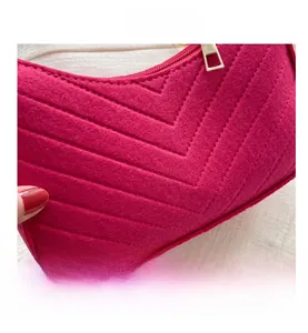 Detailed close-up of fuchsia felt handbag featuring elegant V-shaped quilted stitching