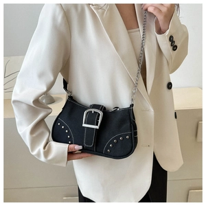 Close-up of black denim shoulder bag featuring silver buckle, rivets and chain strap