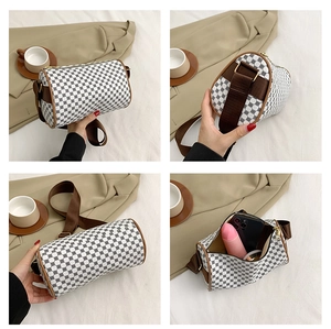 Detail view of cylinder crossbody bag with retro print, showing spacious inner compartment