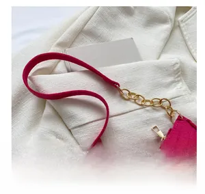 Detail of rose pink quilted velvet shoulder bag with gold chain and metal zipper closure