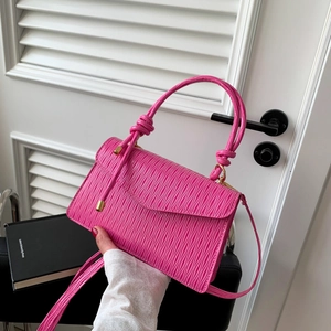 Pink pleated leather shoulder bag with gold metal pendant and knotted handle strap