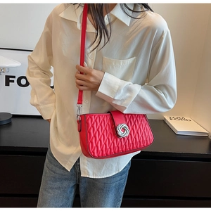 Detail of red quilted PU leather shoulder bag with silver spiral twist lock and strap