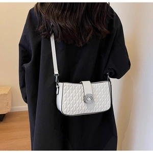 Detailed view of a white quilted crossbody bag with silver twist knot hardware on model