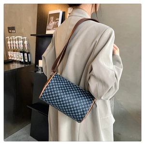 Detail of vintage geometric cylinder bag with brown leather trim and slim shoulder strap