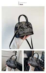 Detailed close-up of a black shell handbag featuring intricate white dragon embroidery patterns