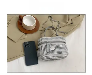 Size comparison of silver rhinestone mini box bag with chain strap next to a mobile phone