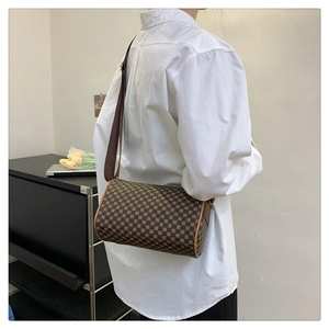 Brown vintage cylinder bag with geometric patterns and broad textile shoulder strap