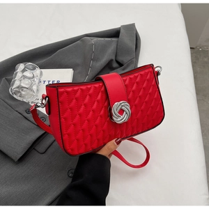 Close-up of red quilted PU leather shoulder bag with a silver metal twist lock closure