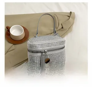 Detail view of the silver rhinestone cylindrical handbag with chain and zipper detail