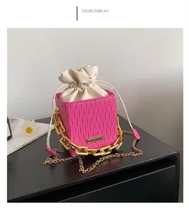 Detailed close-up of pink checkered bucket bag with gold chain and drawstring closure
