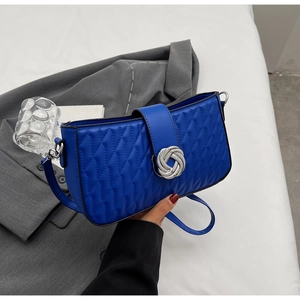 Detail of Klein blue quilted shoulder bag with silver knot twist lock and leather strap