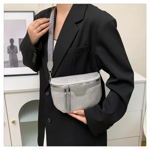 Detail of silver rhinestone saddle bag with zigzag wide strap worn on black blazer