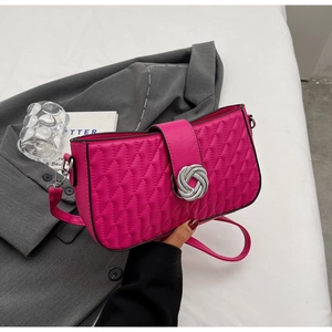 Detail of fuchsia quilted handbag featuring a silver twist lock and textured finish