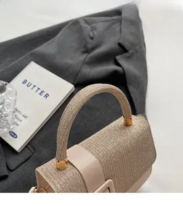 Detail of glittery champagne handbag with metal buckle on a dark suit background