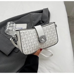 Detail view of a white quilted shoulder bag featuring silver knot-shaped metal buckle