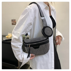 Detail of black crossbody bag with silver studs and a patterned wide strap and coin pouch