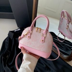 Pink shell-shaped handbag in faux leather and floral jacquard with gold hardware
