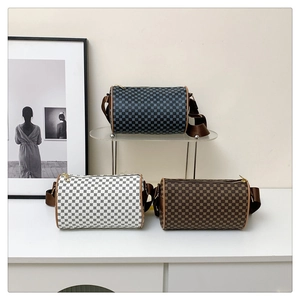 Detailed view of cylindrical crossbody bags in checkered and retro patterns on a display