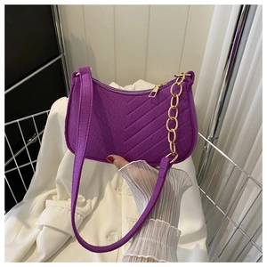 Detail of purple felt shoulder bag featuring V-shaped quilting and gold metal chain strap