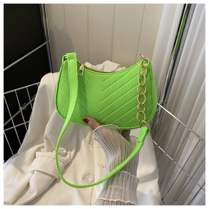 Detail of neon green shoulder bag featuring diagonal texture and gold chain link