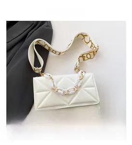 Detailed macro view of white geometric textured crossbody bag with decorative acrylic chain