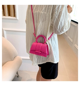 Détail du mini sac rose fuchsia avec texture grainée et bandoulière en chaîne