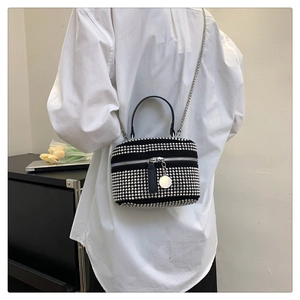 Detail view of black rhinestone handbag with silver metal studs and chain strap