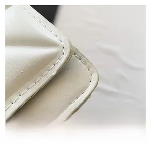 Detail shot of premium quilted white leather texture and precise stitching on the handbag