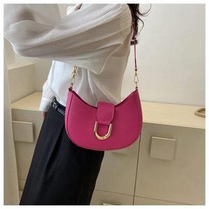 Détail du sac demi-lune rose vif avec une boucle en fer à cheval dorée élégante