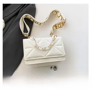 Detailed top view of a white quilted crossbody bag with stylish wide straps and phone reference