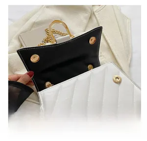 Detail view of white quilted crossbody bag with dual magnetic closures and gold chain strap