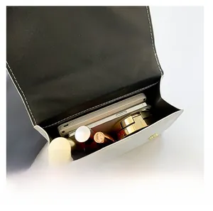 Interior view of black and white handbag showing capacity for phone and cosmetics