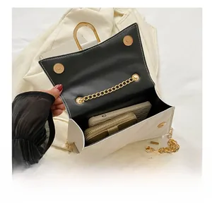 Internal view of white quilted crossbody bag holding a smartphone and zipper wallet