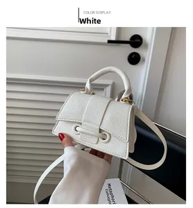 Detail showing white litchi pattern mini hourglass bag with golden hardware and handle