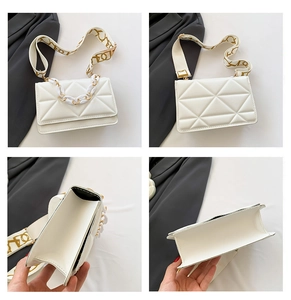 Macro view of white quilted crossbody bag featuring chain detail and wide patterned strap