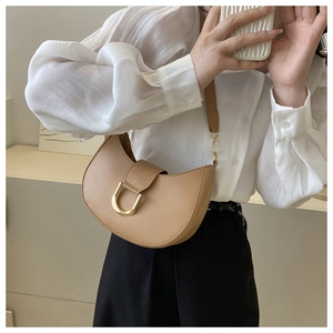Détail du sac bandoulière demi-lune kaki avec boucle dorée et texture en cuir lisse