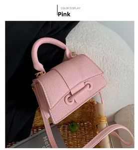 Detail of pink small square crossbody bag with litchi texture and leather knot accent