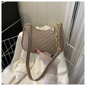 Detail of tan chevron stitched shoulder bag with gold chain and soft suede texture