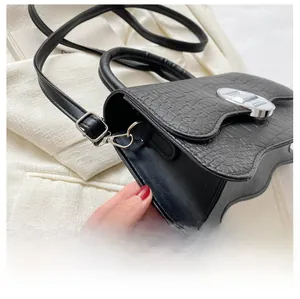 Détail du sac à main noir texture crocodile en cuir PU avec fermoir rotatif argenté