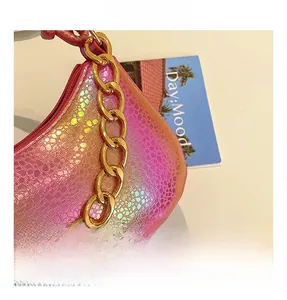 Detailed macro view of pink metallic snakeskin texture and chunky gold chain strap