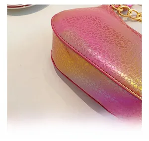 Detail of pink and orange gradient handbag featuring embossed snakeskin and gold chain link