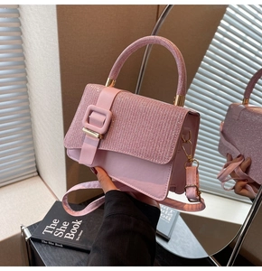 Detail of pink glitter patchwork handbag with gold hardware and leather strap