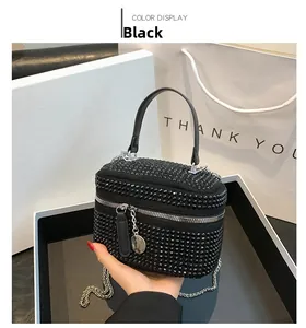 Detail of black rhinestone mini vanity bag with silver chain strap and velvet texture