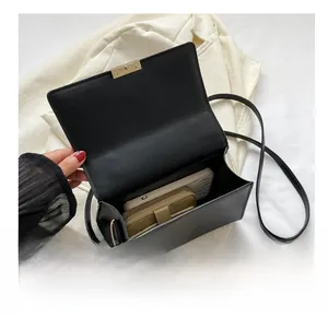Top view of a black leather crossbody bag showing interior capacity for phone and wallet