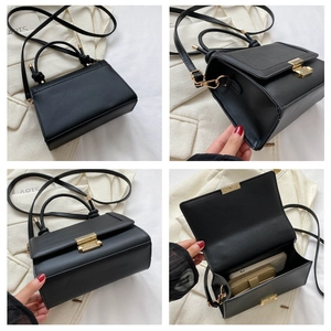 Detail view of black crocodile pattern flap bag showing golden buckle and interior capacity