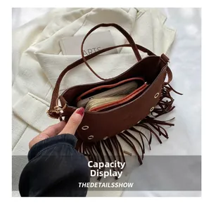 Detail view of the spacious interior capacity of this dark brown suede tassel crescent bag